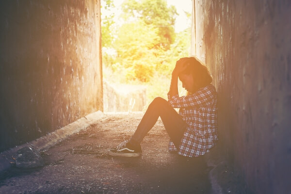menina triste sentada sozinha no chão